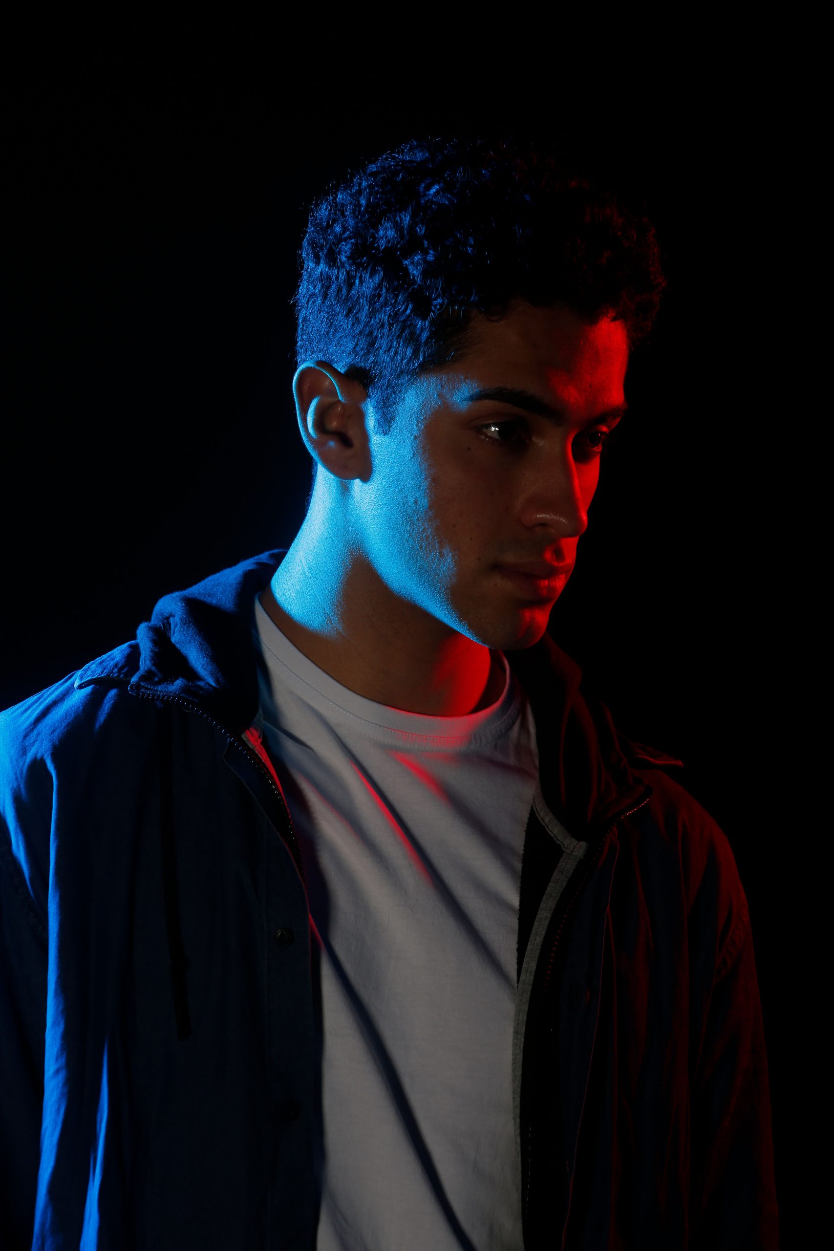 Man standing with red and blue lights shining 
