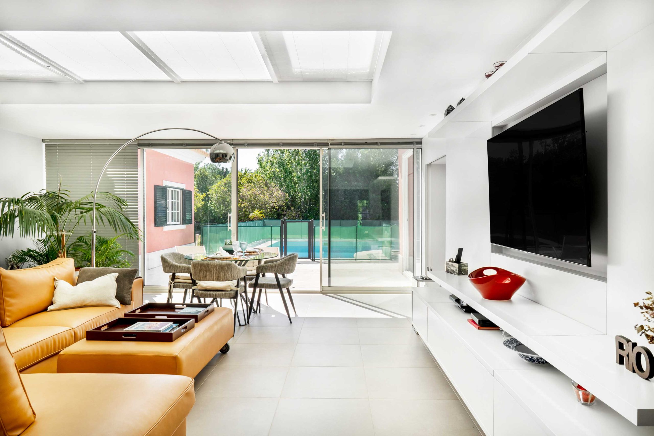 Sala de estar com televisão e passagem para o terraço